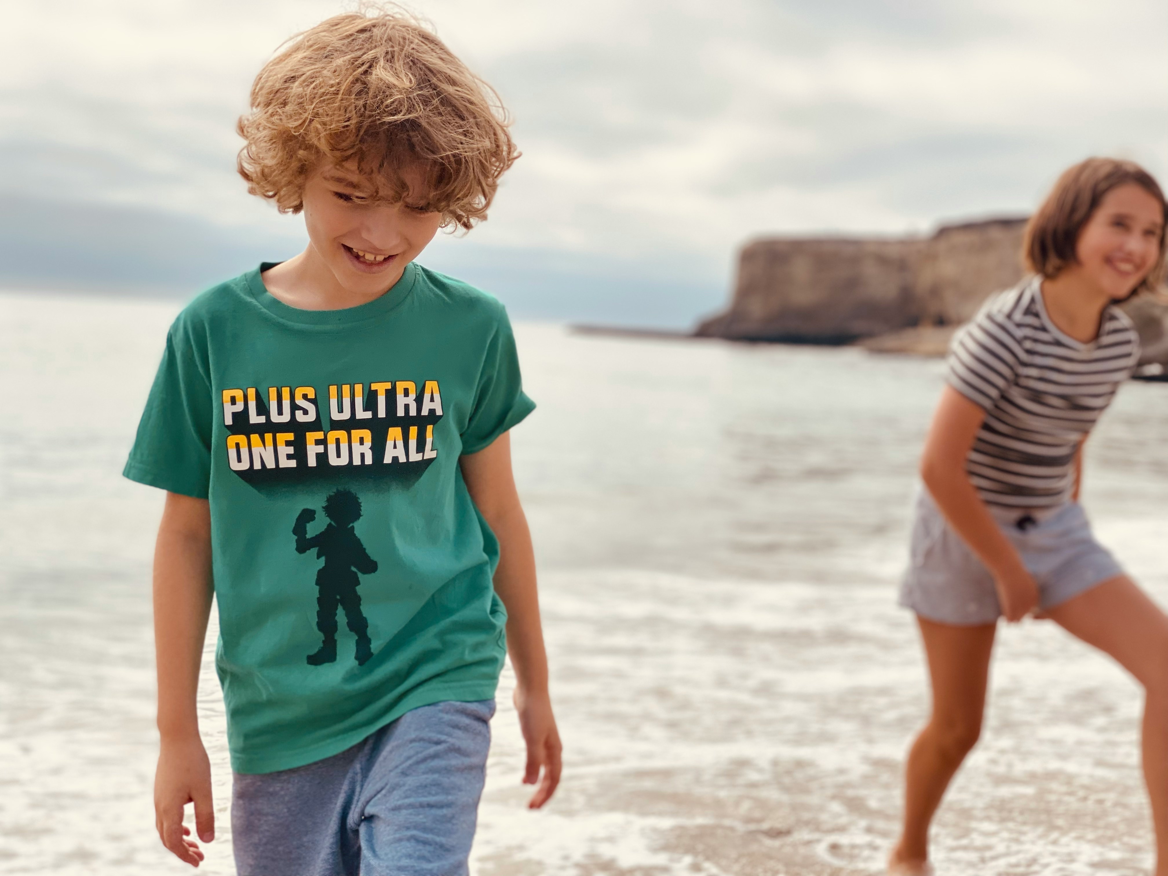 boy in blue crew neck t-shirt standing on beach during daytime